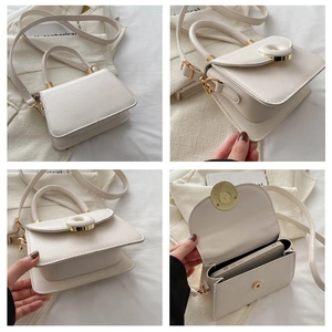 Detail view of cream PU leather handbag showing internal capacity and gold metal buckle