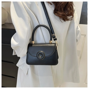 Black structured mini crossbody bag with a round gold buckle and chic top handle