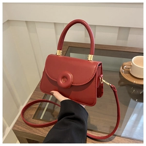 Detail of red small square bag with doughnut buckle and adjustable strap
