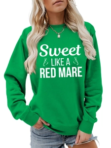 Detail of green crewneck sweatshirt featuring white horse graphics and artistic lettering