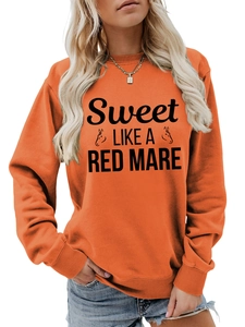 Detail view of bright orange crewneck sweatshirt with Sweet Like A Red Mare graphic print