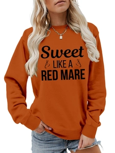 Detail of orange crewneck sweatshirt featuring Sweet Like a Red Mare graphic print