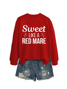 Flat lay of a red crewneck sweatshirt with white text and horse print with denim shorts