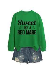 Detail of green crewneck sweatshirt with 'Sweet LIKE A RED MARE' print and denim shorts