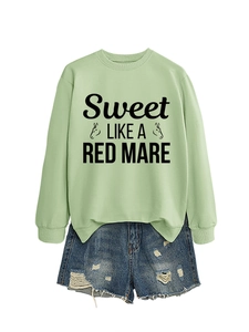 Flat lay of green crewneck sweatshirt with text and frayed denim shorts outfit set