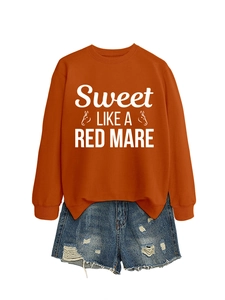Detail of terracotta crewneck sweatshirt with horse graphic and distressed denim shorts