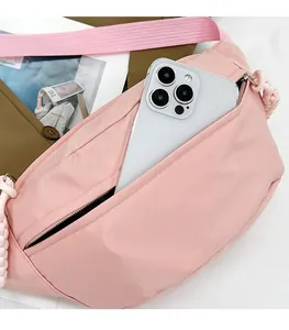 Detail showing the inner storage of a pink nylon waist bag with a large smartphone