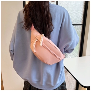 Close-up of sakura pink nylon waist bag with white braided cord zippers on model