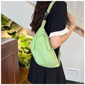 Close-up of mint green nylon chest bag featuring a distinct braided rope zipper pull