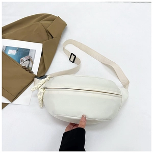 Detail of minimalist cream nylon belt bag with smooth zipper and adjustable strap