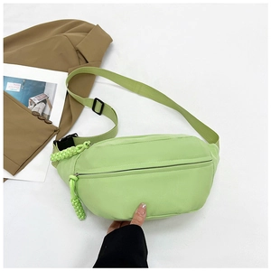 Detail of light green nylon waist bag with adjustable strap and main zipper closure