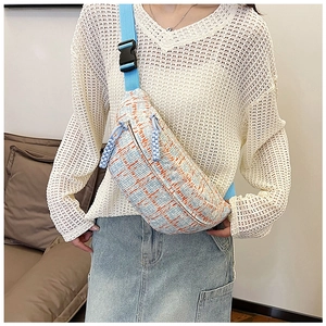 Detail of checkered canvas waist bag with blue tweed texture and adjustable strap buckle