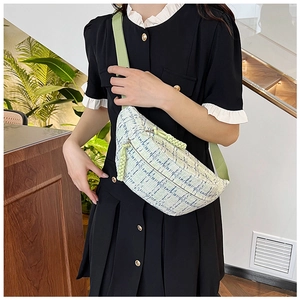 Detail of multi-color woven canvas texture on a crossbody bag with green fabric strap