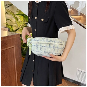 Detailed view of light green plaid tweed belt bag with woven rope zipper pull