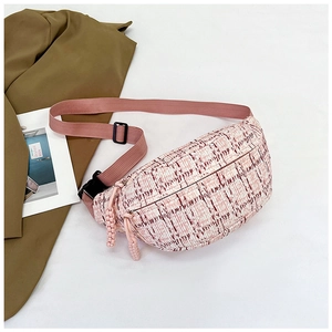 Detail of pink plaid tweed chest bag with woven strap and buckle on neutral background