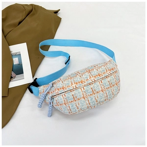 Top view of plaid canvas fanny pack with blue woven strap and double zipper detail