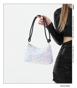 Gros plan des paillettes irisées et de la poignée en corde tressée du sac baguette