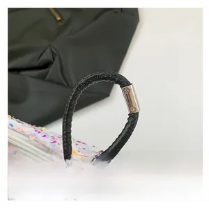 Vue macro d'un sac à paillettes avec bandoulière en cuir noir et fixations en métal argenté
