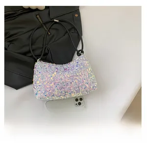 Sac bandoulière à paillettes présenté à côté d'un smartphone pour comparer la taille
