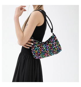 Détail du sac à bandoulière baguette à paillettes multicolores porté par un mannequin