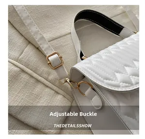 Detail of adjustable golden buckle and premium quilted texture on white handbag