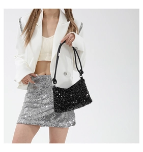 Détail du sac sous le bras à paillettes noires avec texture scintillante sur un mannequin