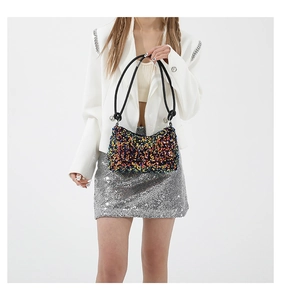 Détail du sac baguette à paillettes colorées avec bandoulière en corde noire sur modèle