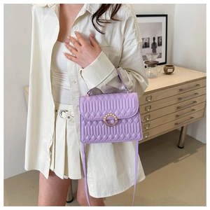 Close-up of lilac quilted crossbody bag featuring elegant pearl buckle and V-pattern