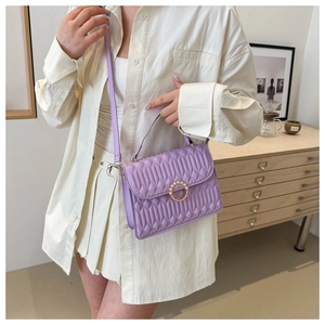 Detail of lavender quilted crossbody bag with pearl gold ring clasp and slim strap