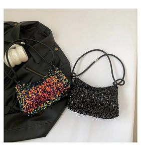 Gros plan de sacs sous les bras à paillettes arc-en-ciel et noires sur une surface blanche