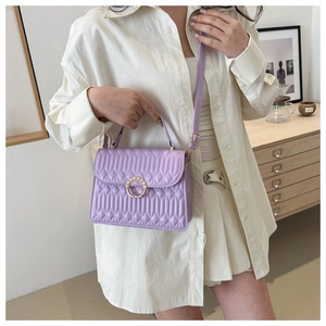 Detailed view of lavender quilted crossbody bag with pearl buckle and golden ring