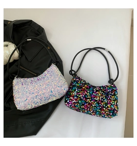 Détail de sacs hobo à paillettes scintillantes en blanc irisé et noir multicolore