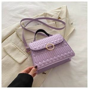 Detail of purple quilted bag with gold ring buckle and elegant pearl embellishments