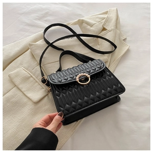 Detail of black quilted bag featuring elegant pearl-encrusted gold ring buckle and strap