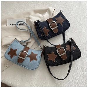 Detailopname van retro denim schoudertassen met leren sterrenpatches en metalen gespen