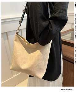 Detail of cream tote bag featuring textured faux leather and ethnic print wide strap