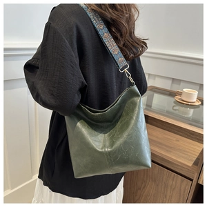 Dark green hobo bag featuring ethnic style embroidered strap and soft vegan leather finish