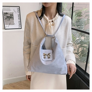 Detailed view of lavender blue satin tote bag with silver metal bow and slim strap