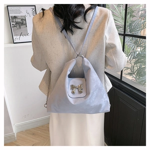 Detailed back view of a lavender soft PU hobo bag with a silver bow on a model