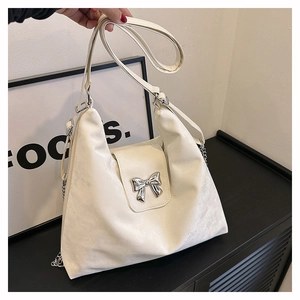 Close-up of white soft PU leather bag featuring a silver bow buckle and adjustable strap