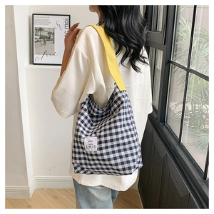 Détail du cabas en toile à carreaux vichy bleu et blanc avec large bandoulière jaune vif