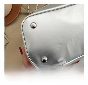 Détails de sac argenté métallisé montrant les coutures et les pieds de protection