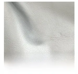 Gros plan sur la texture du similicuir blanc avec des détails de broderies colorées