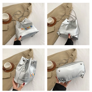 Détails du sac seau argenté avec broderies colorées et bandoulière en chaîne