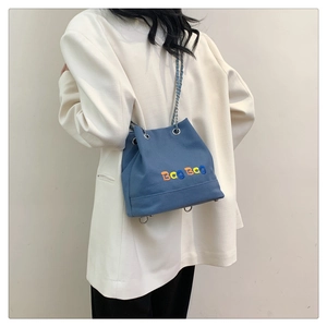 Détail du sac seau en toile bleue avec broderie colorée Bag Bag et bandoulière en chaîne