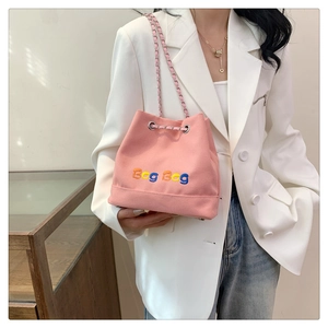 Détails du sac seau en toile rose avec broderie colorée et bandoulière chaîne