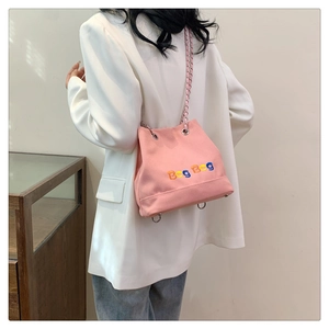 Vue détaillée du sac en toile rose avec broderie Beg Bag et bandoulière en chaîne