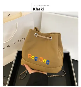 Détail du sac seau en toile kaki avec broderie Bag Bag colorée et bandoulière chaîne métal