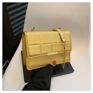 Chic quilted yellow shoulder bag with gold chain strap and metal lock closure
