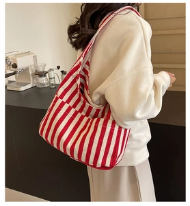 Red and white striped canvas tote bag detail featuring a side pocket in a coffee shop setting